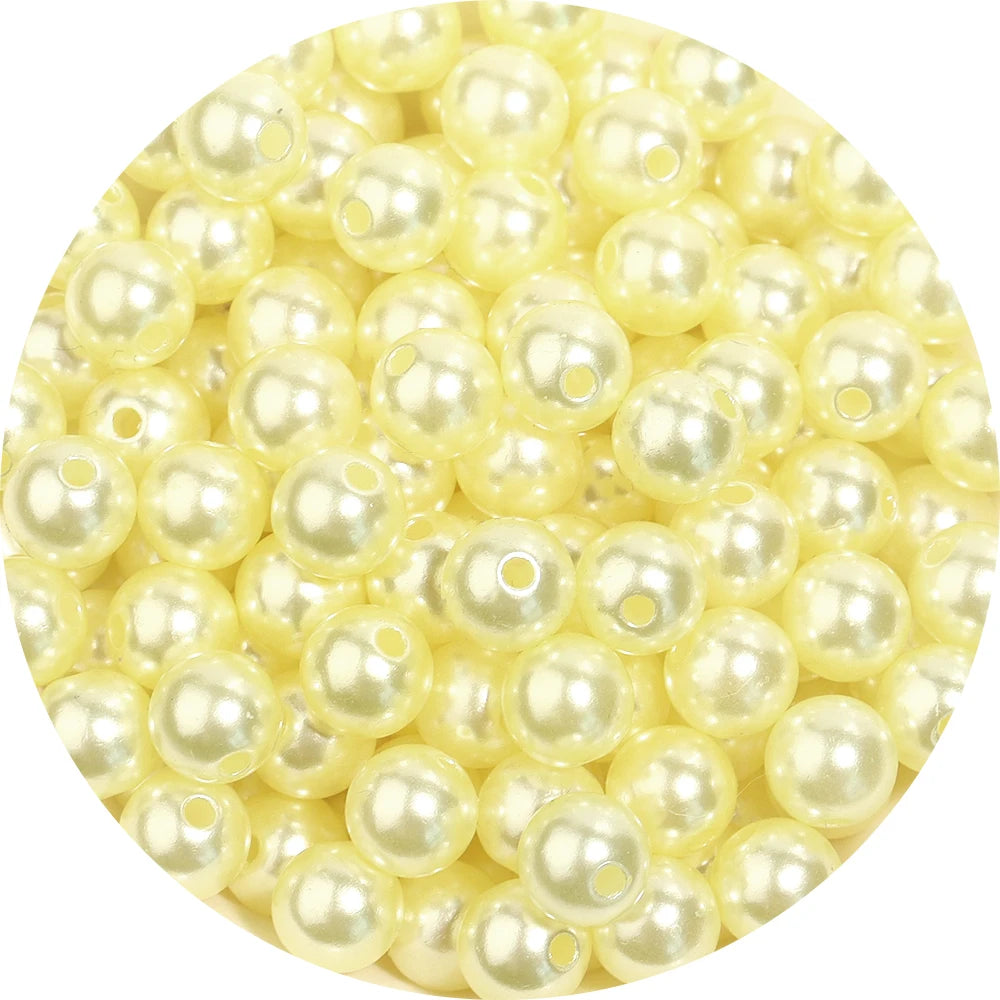 A close-up view of small, round imitation pearl beads in a pale yellow color.