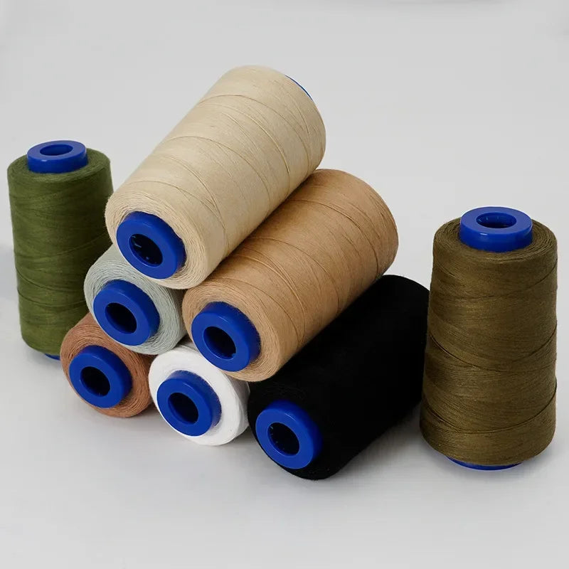 A collection of spools of heavy-duty waterproof sewing thread in various colors including olive green, beige, and black.