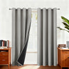 Gray blackout thermal window drapes hanging in a window frame with wooden furniture visible.