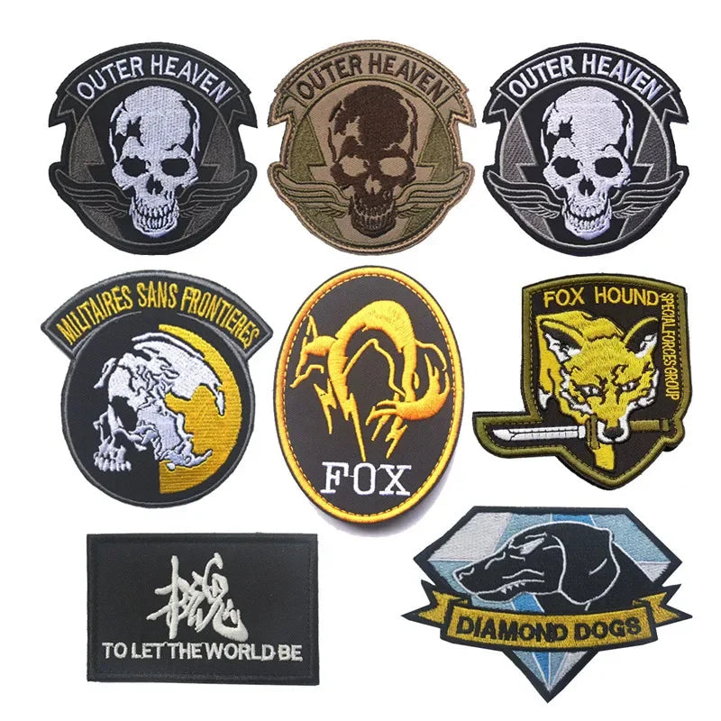 A collection of black, gold, and olive green uniform patches and badges featuring skulls, a fox head, and a dog silhouette.