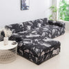 A dark gray and white patterned sofa protector cover lying on a white round stool.