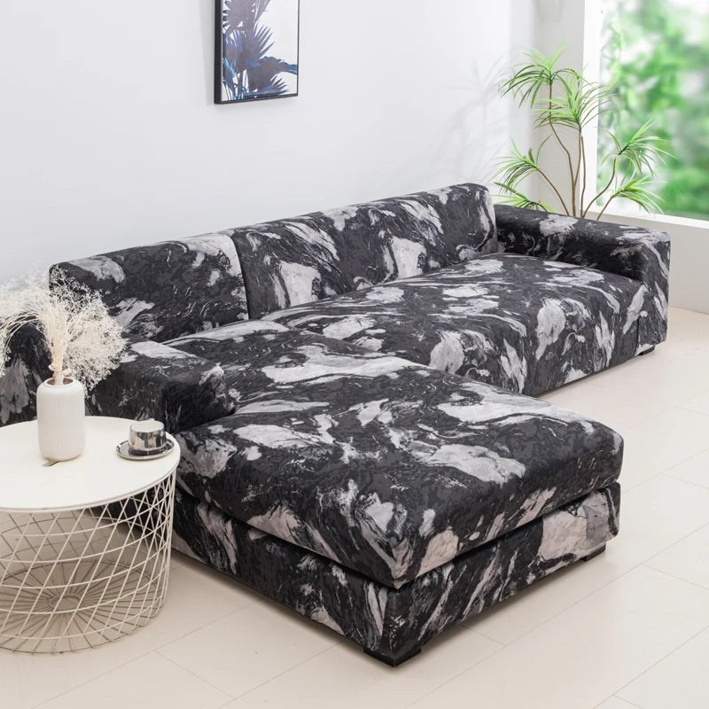 A dark gray and white patterned sofa protector cover lying on a white round stool.