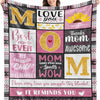 A women models a pink and black flannel throw blanket featuring gold lettering and a sunflower design.