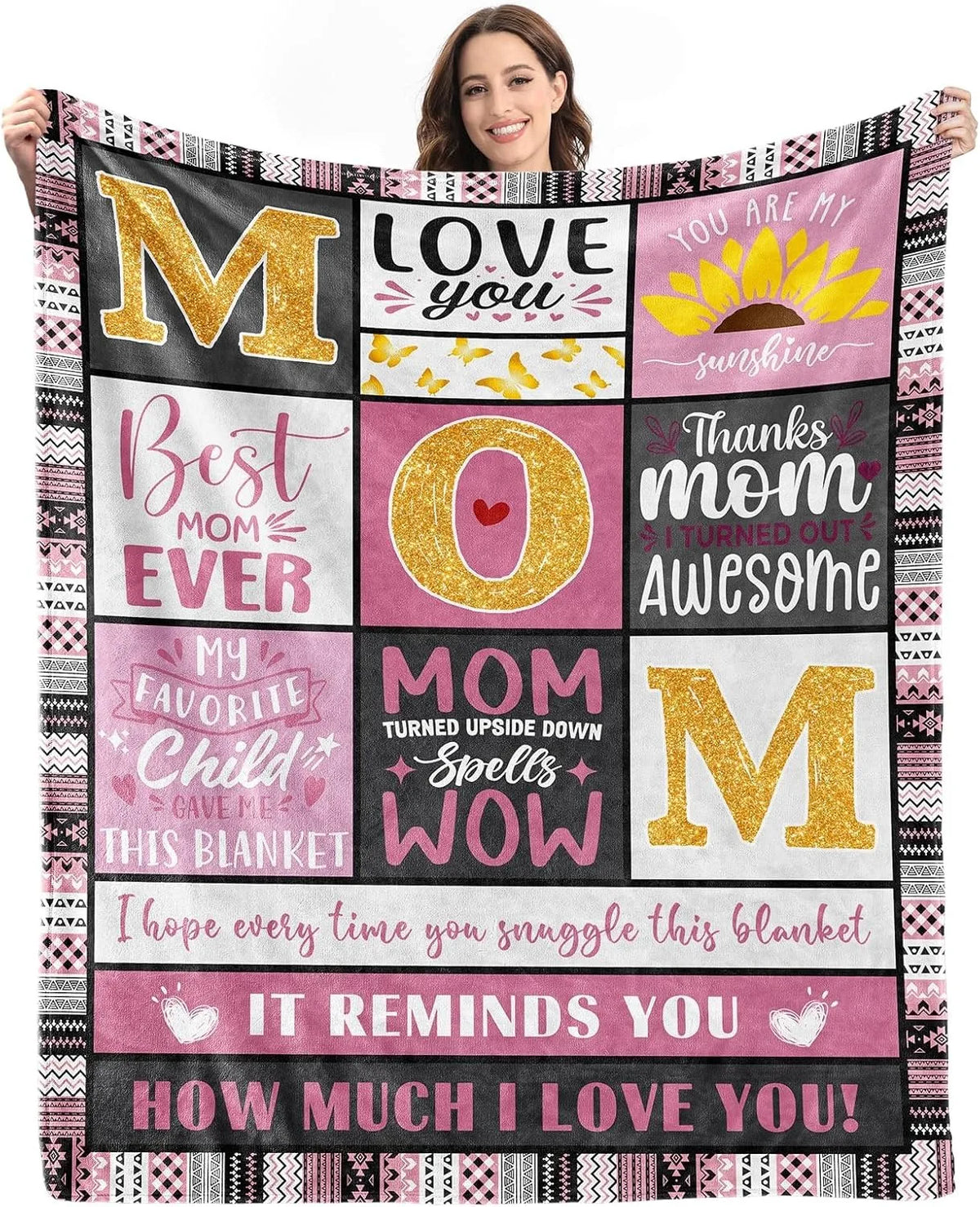 A women models a pink and black flannel throw blanket featuring gold lettering and a sunflower design.