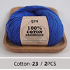 A ball of bright blue 100% organic cotton yarn labeled QJH for knitting and crochet on a wooden tray.