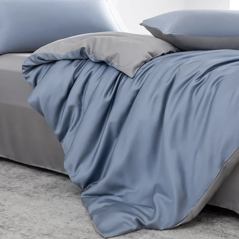 A light blue luxury bamboo duvet cover set draped over a bed with matching pillows and a gray throw.