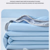 Light blue fabric sheets folded neatly, showing a soft texture and grid pattern.