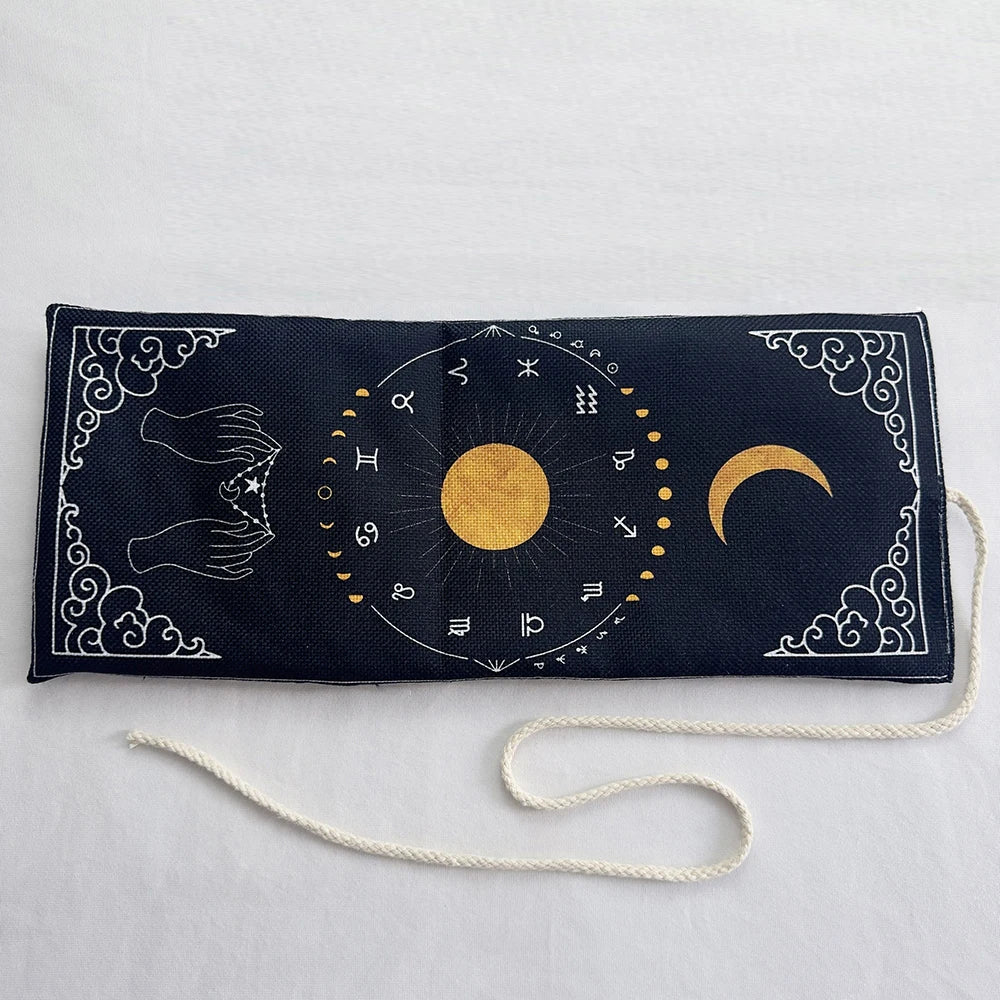 A dark blue pouch with a gold mystical design featuring symbols and a crescent moon, tied with a white cord.