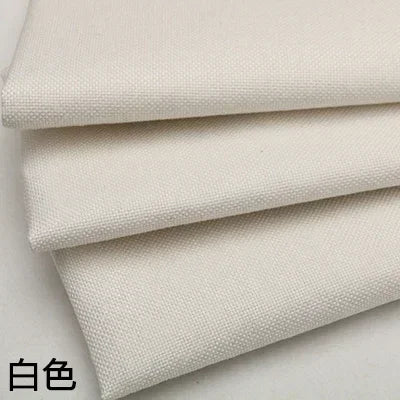 Stack of white coarse linen and cotton fabric rolls