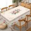 Vintage pink rose sunflower floral tablecloth displayed on a wooden dining table with matching chairs.