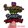 Black embroidered patch with pink, orange, and green text that reads Do something today for a better tomorrow
