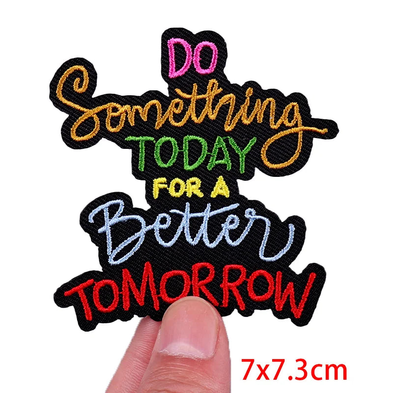 Black embroidered patch with pink, orange, and green text that reads Do something today for a better tomorrow