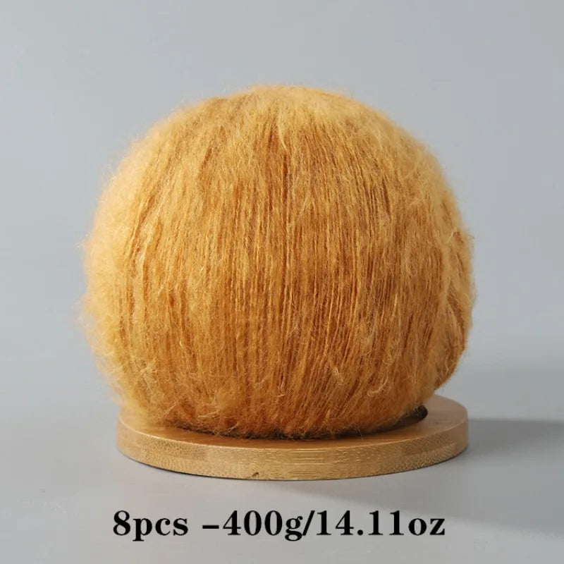A ball of golden orange mohair yarn used for crafting.