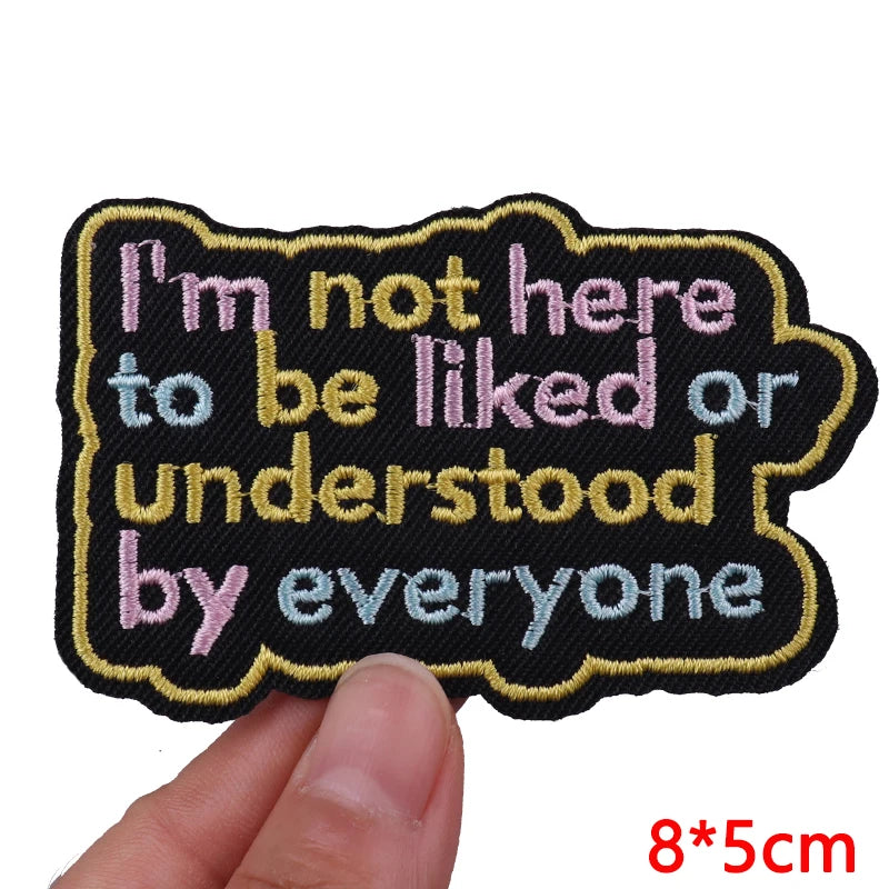 Black embroidered patch with pink text that reads I'm not here to be liked or understood by everyone