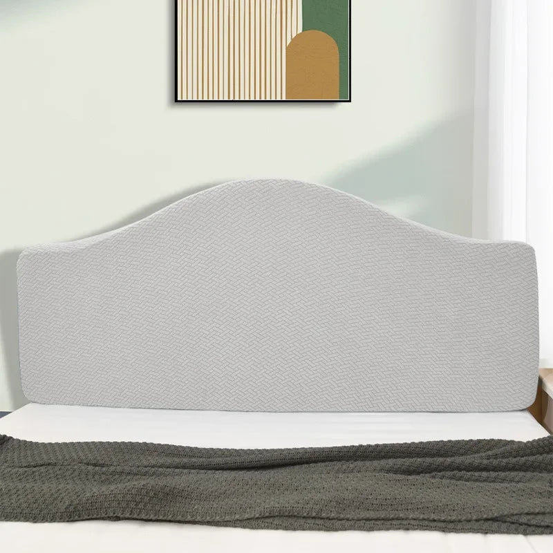A light gray upholstered headboard cover with a subtle diamond pattern on a white bed frame.