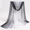 A sheer black and white fabric scarf draped over a display, suitable for sensory play.