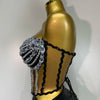 A gold-toned mannequin displays a sparkly diamond two-piece performance set featuring black lace detailing.