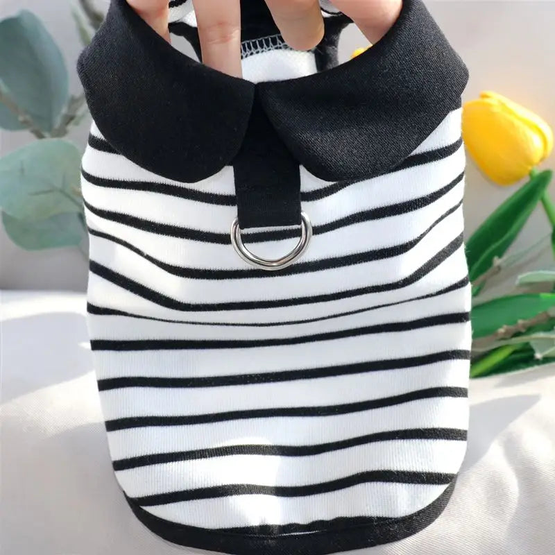 A black and white striped dog dress with a black collar and silver ring closure.