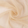 Flowing beige sheer voile curtain fabric draped in soft folds for window decoration