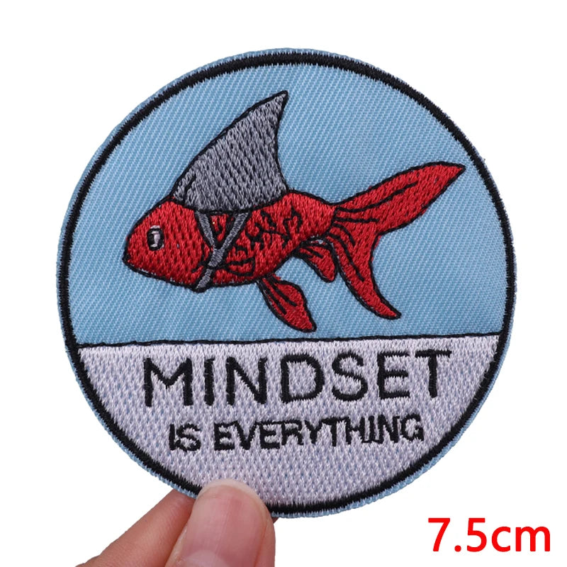 Embroidered patch featuring a red fish silhouette on a light blue background with the text MINDSET IS EVERYTHING.