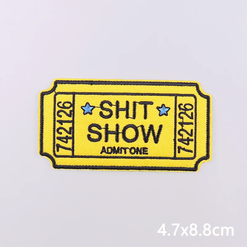 Yellow iron-on embroidery patch with the text SHIT SHOW and a star design on a white background.