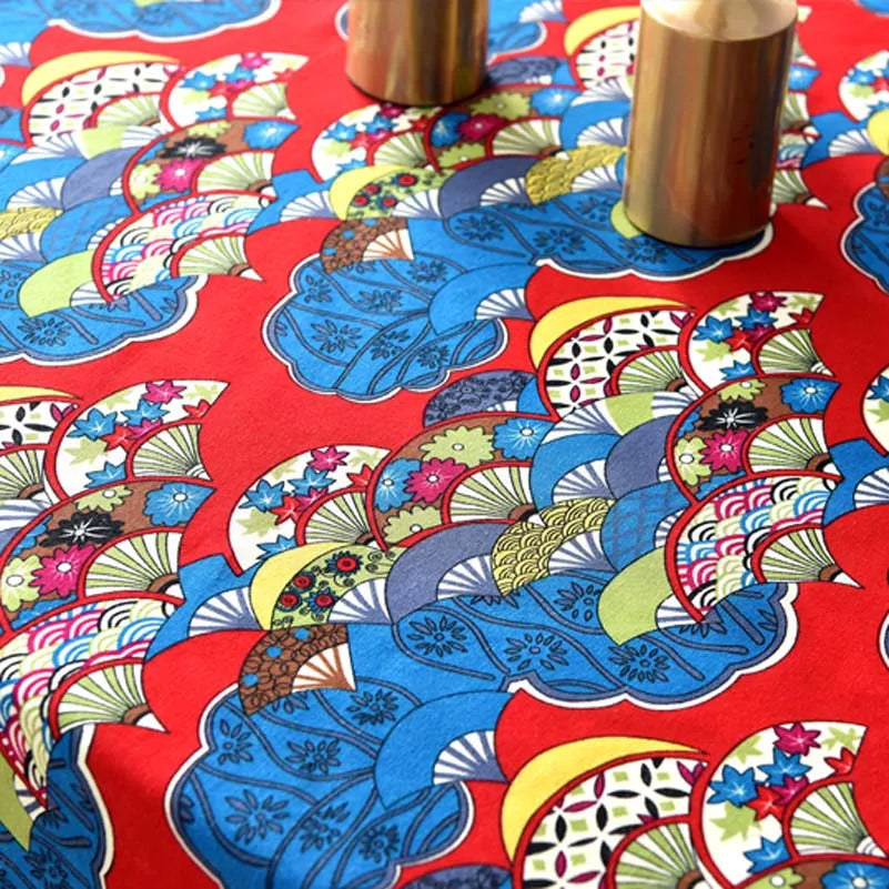 Red fabric with a blue and yellow bohemian print featuring stylized floral and leaf patterns.