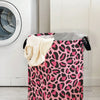 A pink leopard print foldable laundry basket next to a white washing machine.