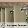 A close-up view of a beige waterproof outdoor curtain with a metal grommet top hanging from a rod.