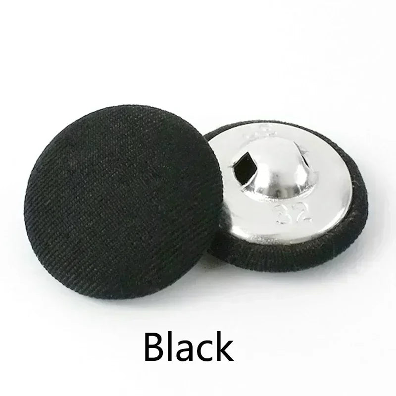 A single black round fabric-covered shank button with a silver backing is shown.