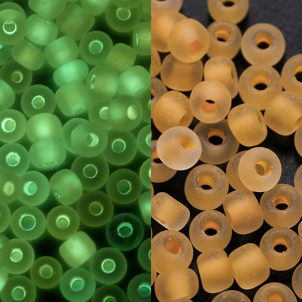 A close-up view of a pack of 3mm glow-in-the-dark green glass seed beads.