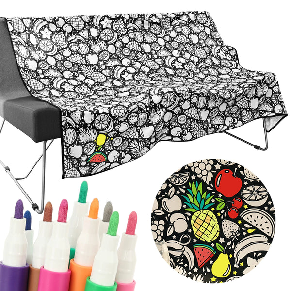 A black and white patterned blanket spread out, next to a set of colorful art markers.