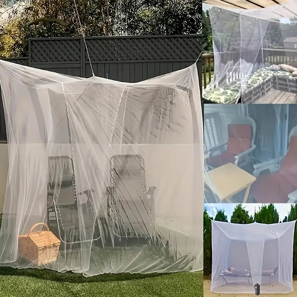 A large white mosquito net draped over outdoor furniture and a wooden basket on a lawn.