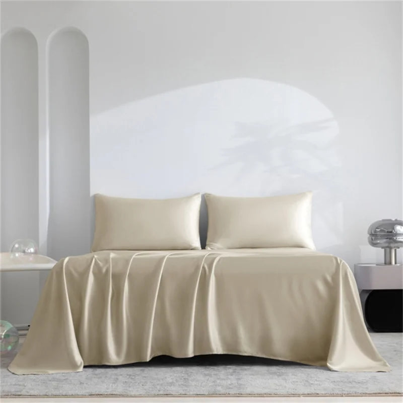 A beige luxury organic bamboo bed sheet set draped over a bed in a bright, minimalist room.