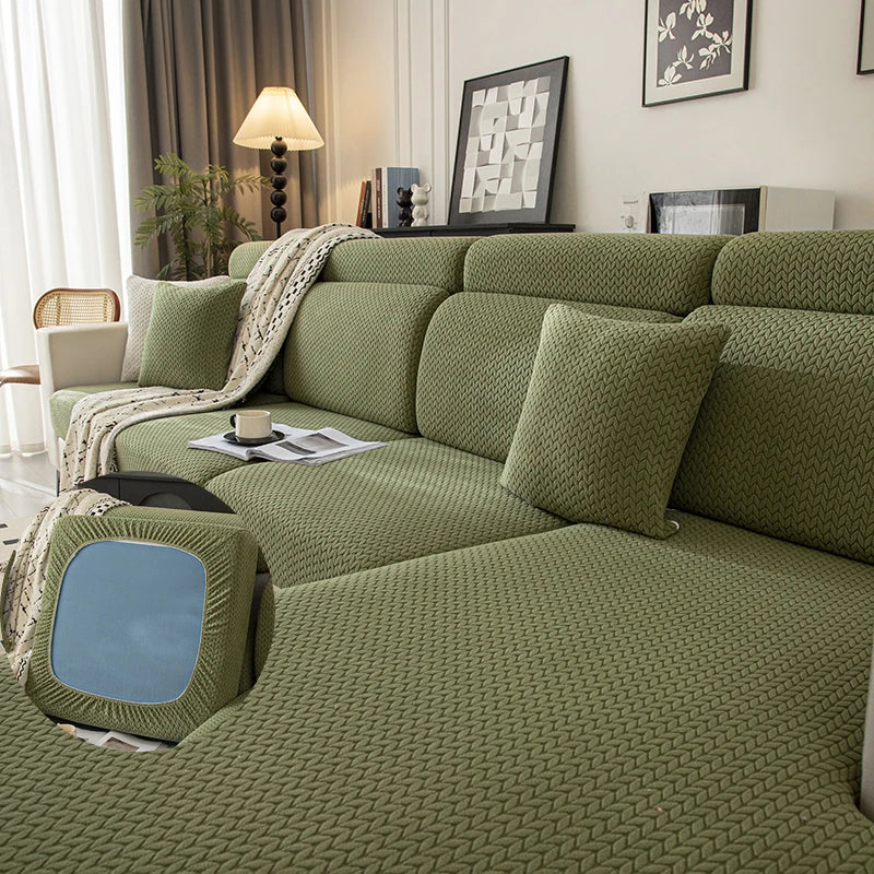 A moss green plush elastic sofa cushion cover displayed on a modern sofa with neutral decor.