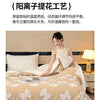 A beige jacquard lambswool blanket is draped over a bed, showing its texture and soft folds.