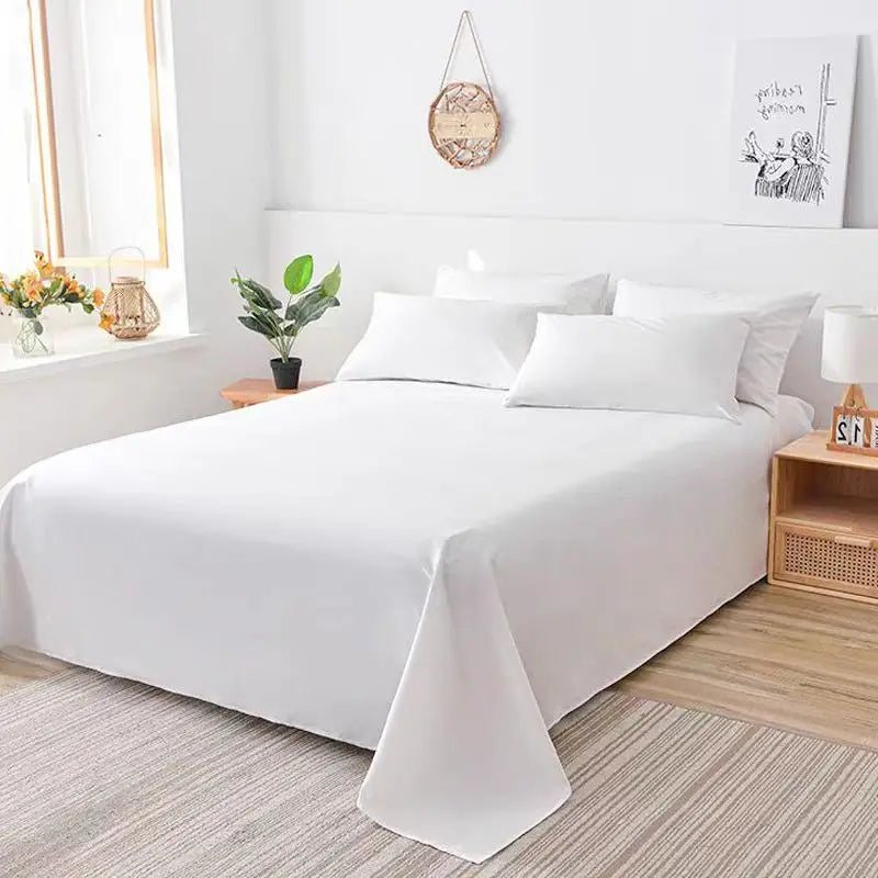 White premium flat bed sheet spread on a bed with natural wood accents and a light gray rug.