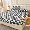 A black and white checkered fitted sheet set is displayed on a bed with pillows.
