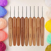 A set of wooden bamboo crochet and knitting needles in various sizes arranged horizontally.