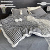 A plaid duvet cover and pillowcase set featuring black and white checkered fabric with lace trim.