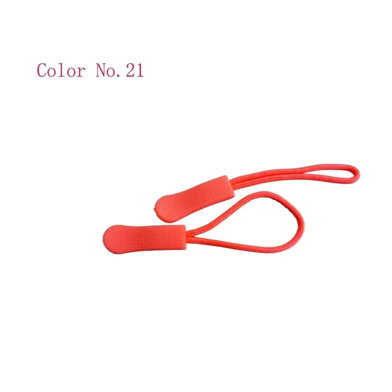 A close-up view of a bright coral red replacement zipper pull for bags and apparel.