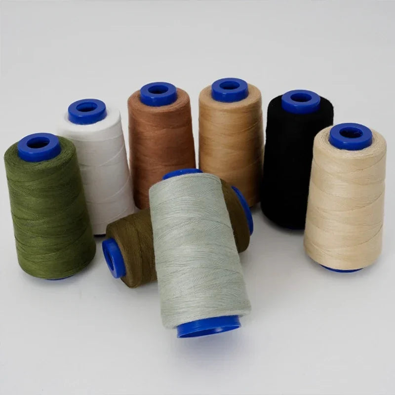 A collection of heavy-duty waterproof sewing thread spools in various colors including green, beige, white, and black.