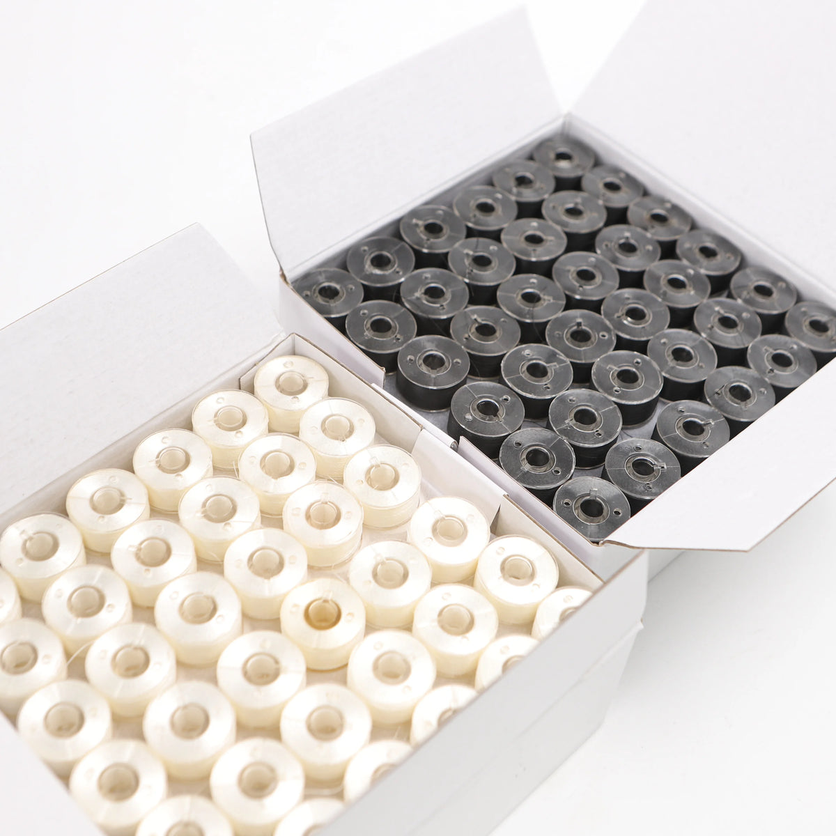 A white box contains 144 small, white polyester embroidery bobbin threads arranged in a grid.