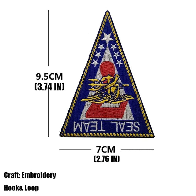 A triangular embroidered patch for a Seal Team, featuring stars and an emblem on a blue background.