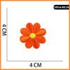 A single orange embroidered flower patch with a yellow center, measuring 4 cm across.