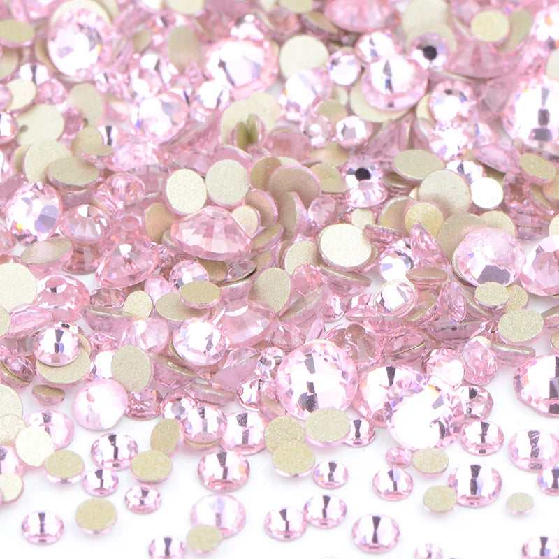 A pile of pink and gold clear glass rhinestones for DIY crafts