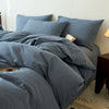 A light blue cotton yarn-dyed duvet cover with matching pillows and bedding on a bed.