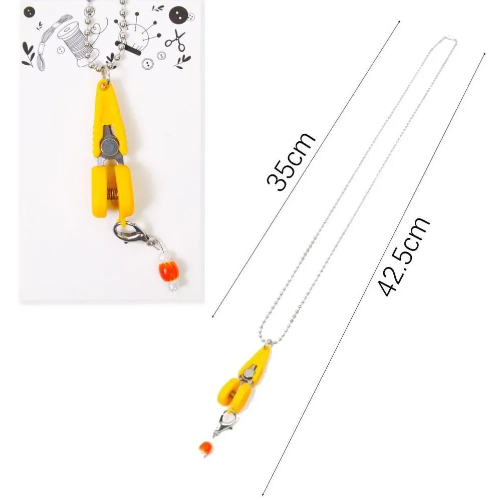 Yellow mini precision sewing scissors with a protective cover displayed against a white background.