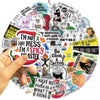 A hand holds a round sticker featuring the text I'm not a hot mess I'm a spicy nastier with various colorful doodles.