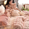 A close-up of a plush rabbit hair bedding set in soft pink and cream tones, featuring fluffy pillows and blankets.