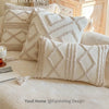 A close-up of cream knit pillow covers on a sofa and bed, styled with natural wood and pottery.